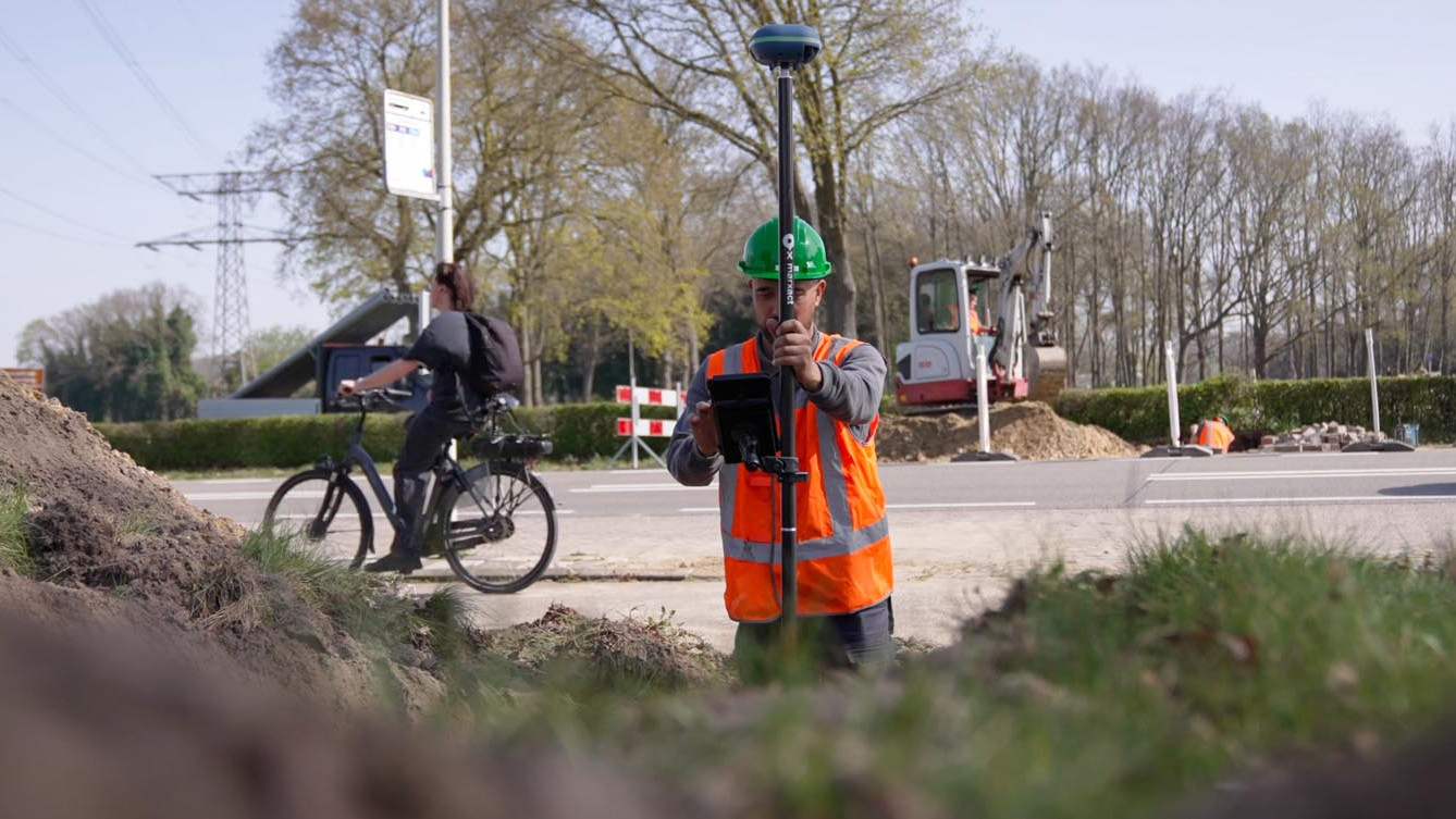 Medewerker voert een GPS-inmeting uit langs de weg