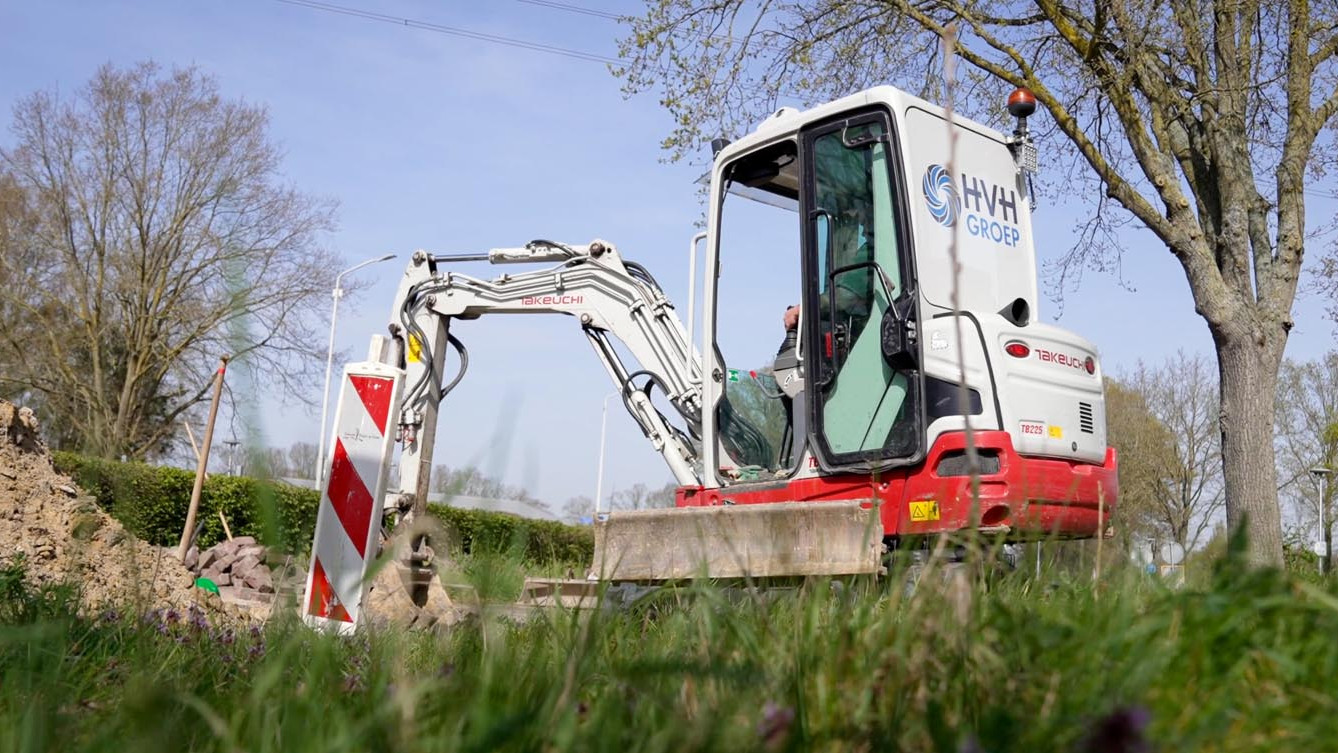 Minigraver van Verstraten aan het werk bij een sleuf