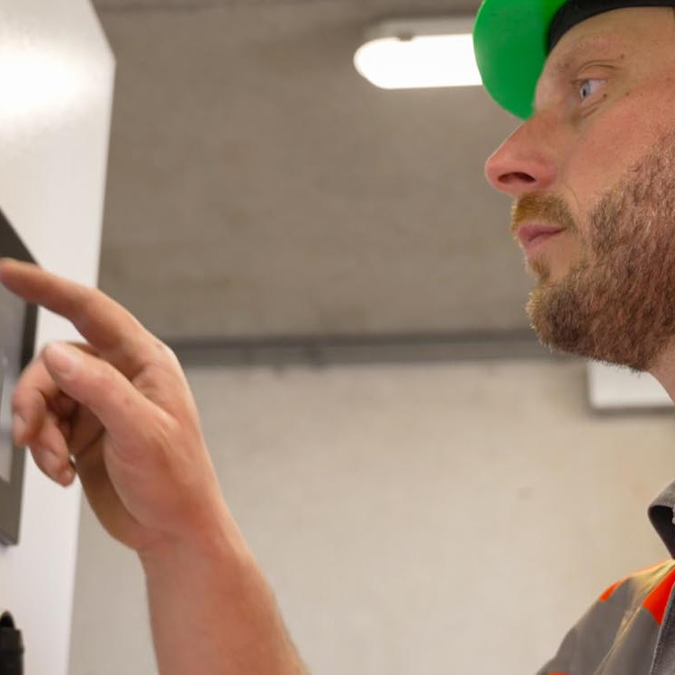 Medewerker bedient het bedieningspaneel van een pompinstallatie
