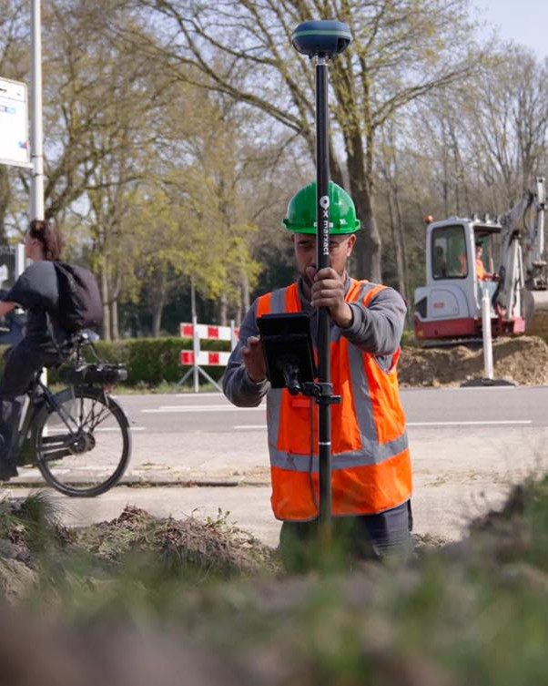 Medewerker voert een GPS-inmeting uit langs de weg