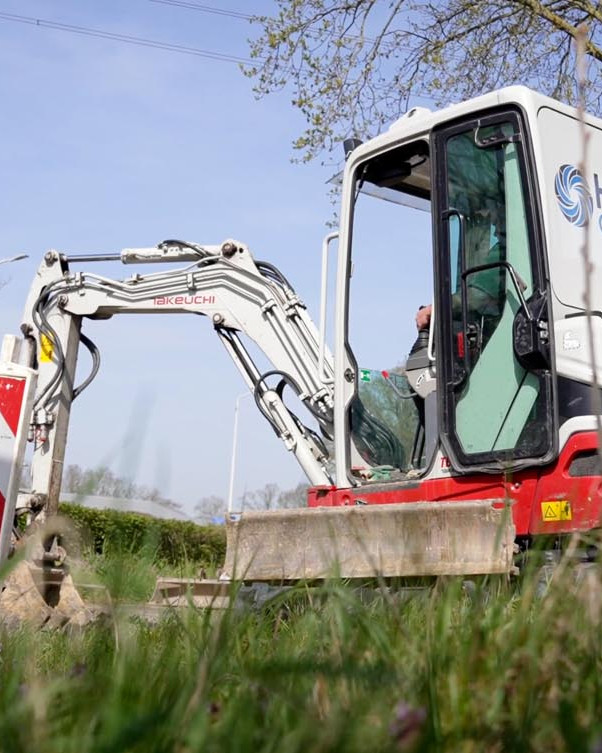 Minigraver van Verstraten aan het werk bij een sleuf